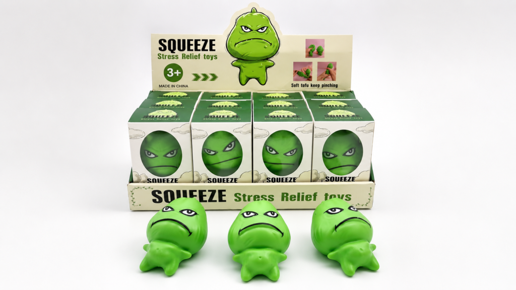 Novelty toy packaging with green squeeze toys in individual retail boxes and display tray