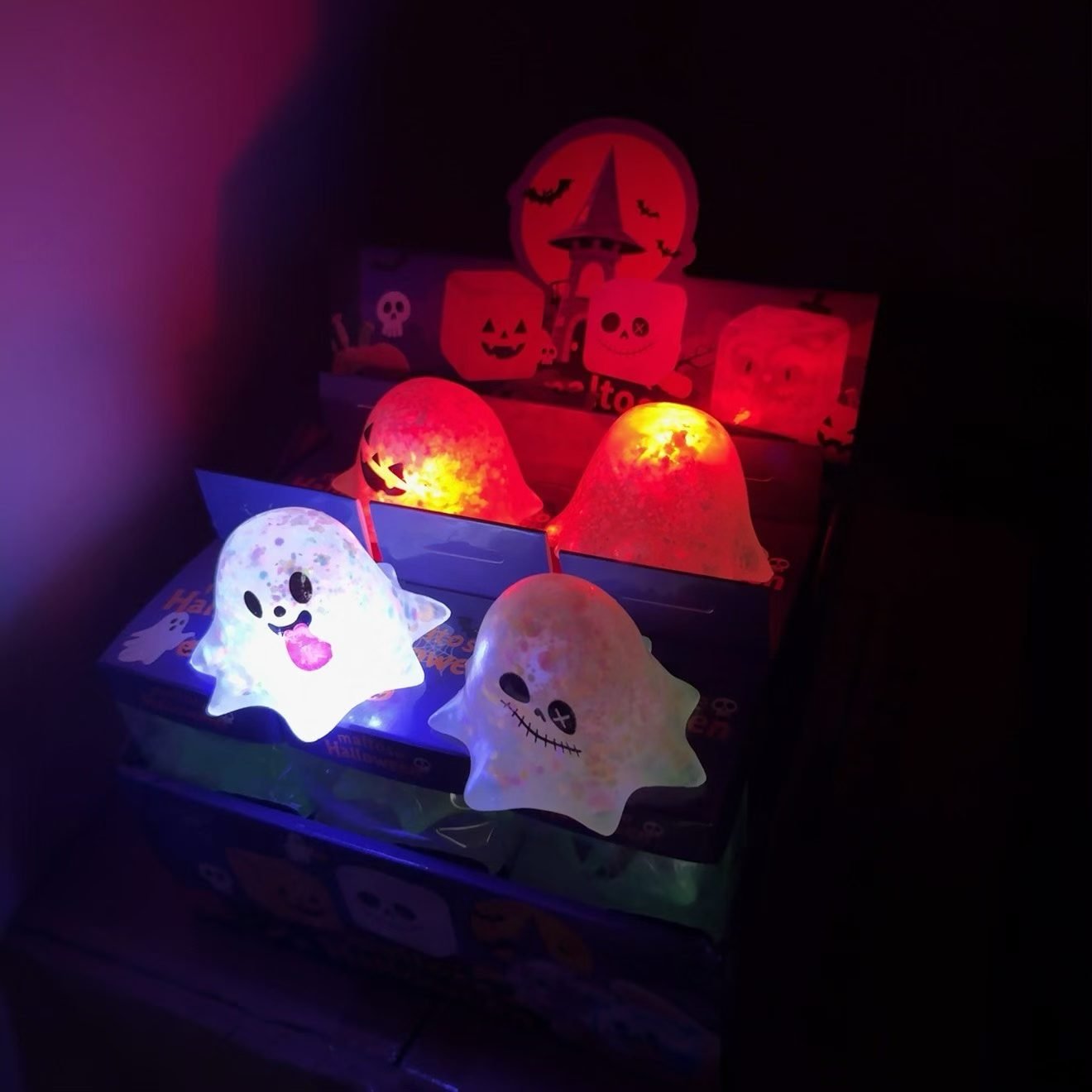 Light-up Halloween ghost squishy toys glowing in assorted colors