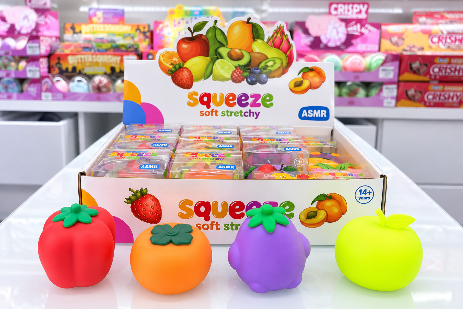 Fruit squeeze toy assortment with individual retail packs arranged in a countertop display box